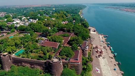 A drone shot of Ahilya Fort beside a river