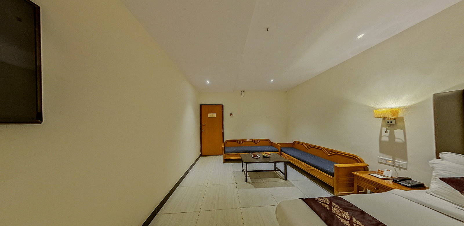 Spacious family room at Lords Eco Inn Dahej with L-shaped seating, coffee table, additional beds, and premium hospitality features