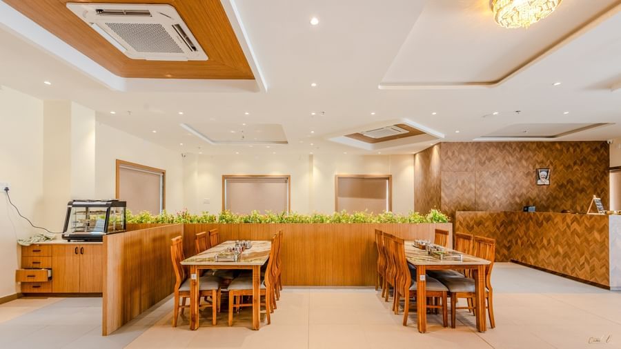 Side view of 2 long dining tables at the restaurant at Daksh The Grand Goverdhan, Dwarka,
