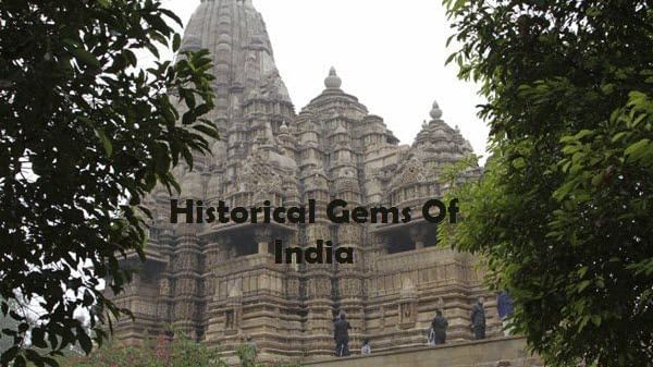 A stone temple structure with 3 towers and carvings,surrounded by trees with text 'Historical Gems Of India' in the image.