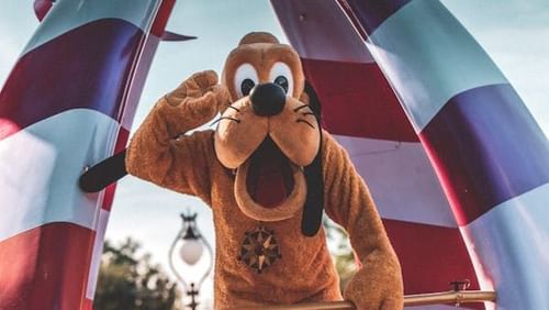 A person in cartoon dog costume waving.