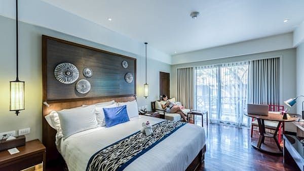 Image of a room with bed and lights hanging on both sides of the bed.