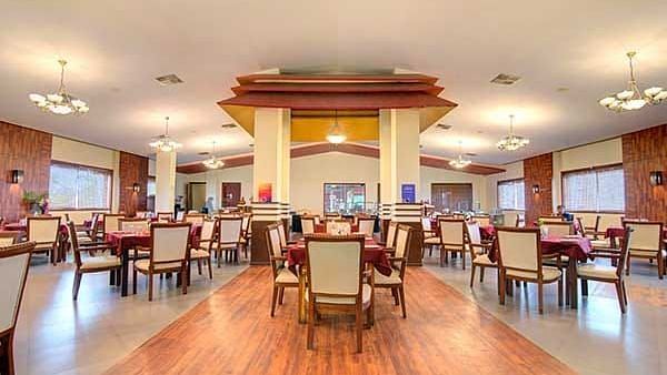 a restaurant with chairs set up in clusters - Camel Valley Resort, Igatpuri