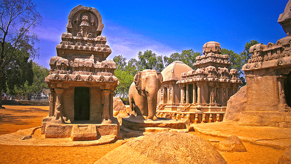 Multiple rock-cut temples with carved figures and an elephant sculpture near Hotel Mamallaa Heritage, Mahabalipuram.