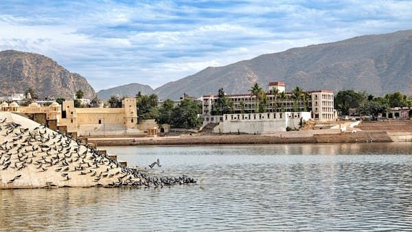 An image of a lake with a fort and mountain in the background and a clear sky