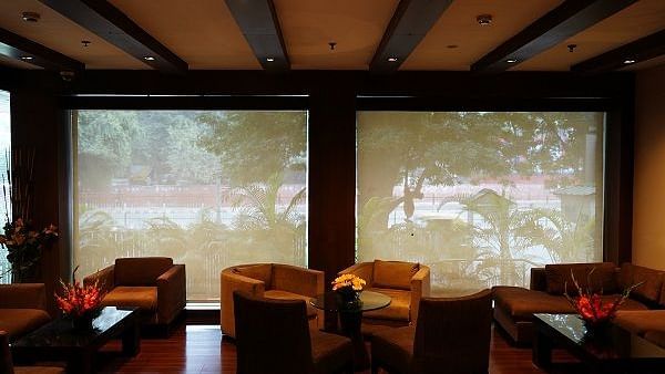 sofa arranged against a large window at Shervani Nehru Place, New Delhi