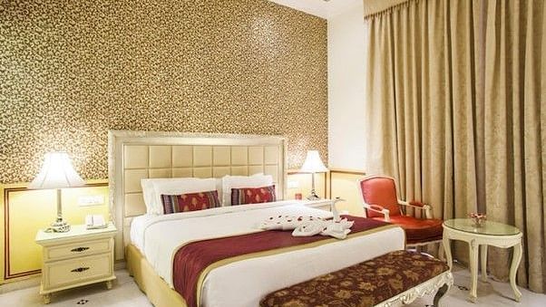 Image of a room with a bed, side tables and a chair at Rajasthali Resort & Spa Jaipur.