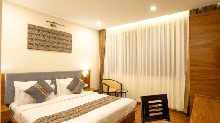 Elegant Deluxe Room at Voyage The Royal Retreat with plush bedding, warm lighting, and contemporary décor.