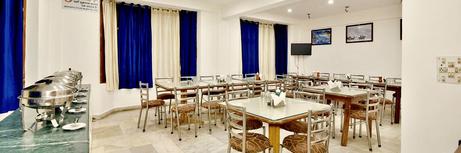 Well-lit interiors of the restaurant at DLS Hotel Devlok, Manali with the buffet arrangement towards the side