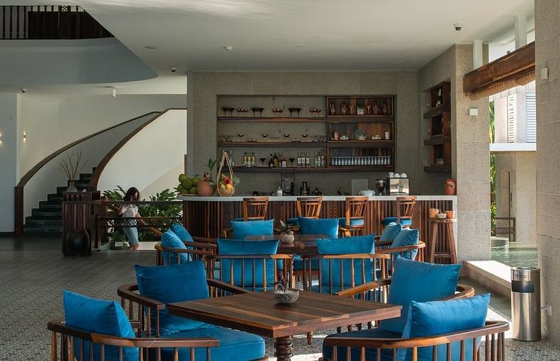 A restaurant with flower printed tiles, wodden chairs and a wooden ceiling - Alibu Resort Nha Trang
