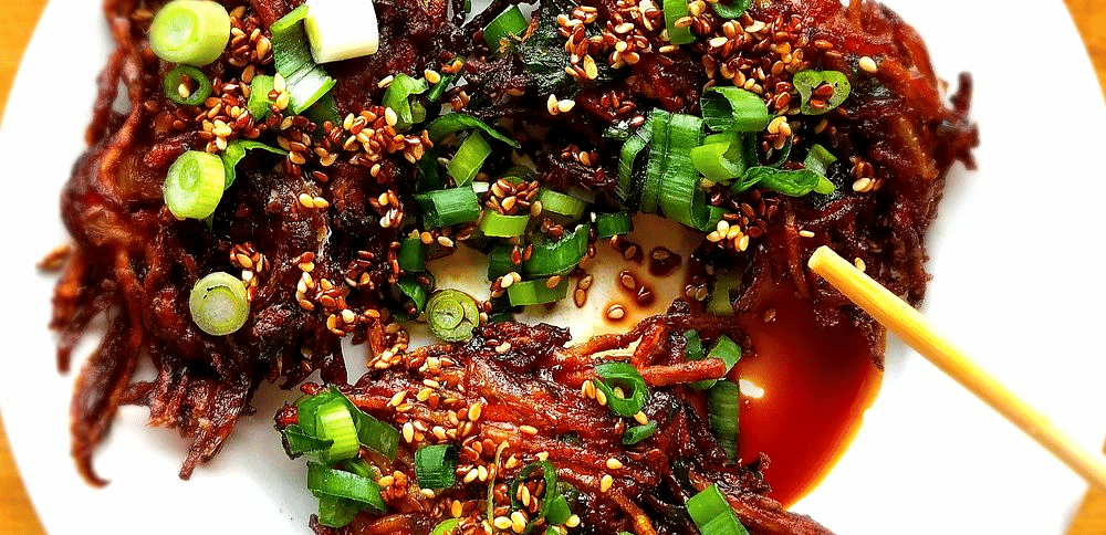 Overhead shot of a plate with food and with chopsticks.
