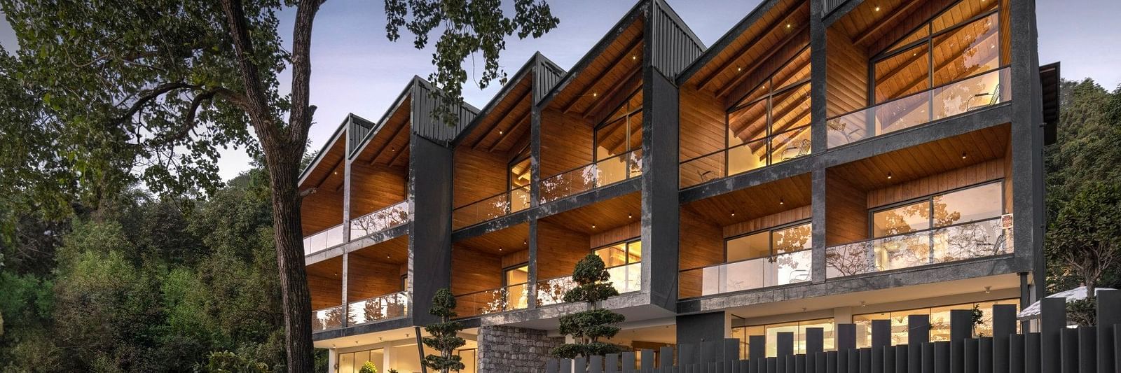 A facade image of the hotel covered in lush greenery - The Samai, Bhimtal