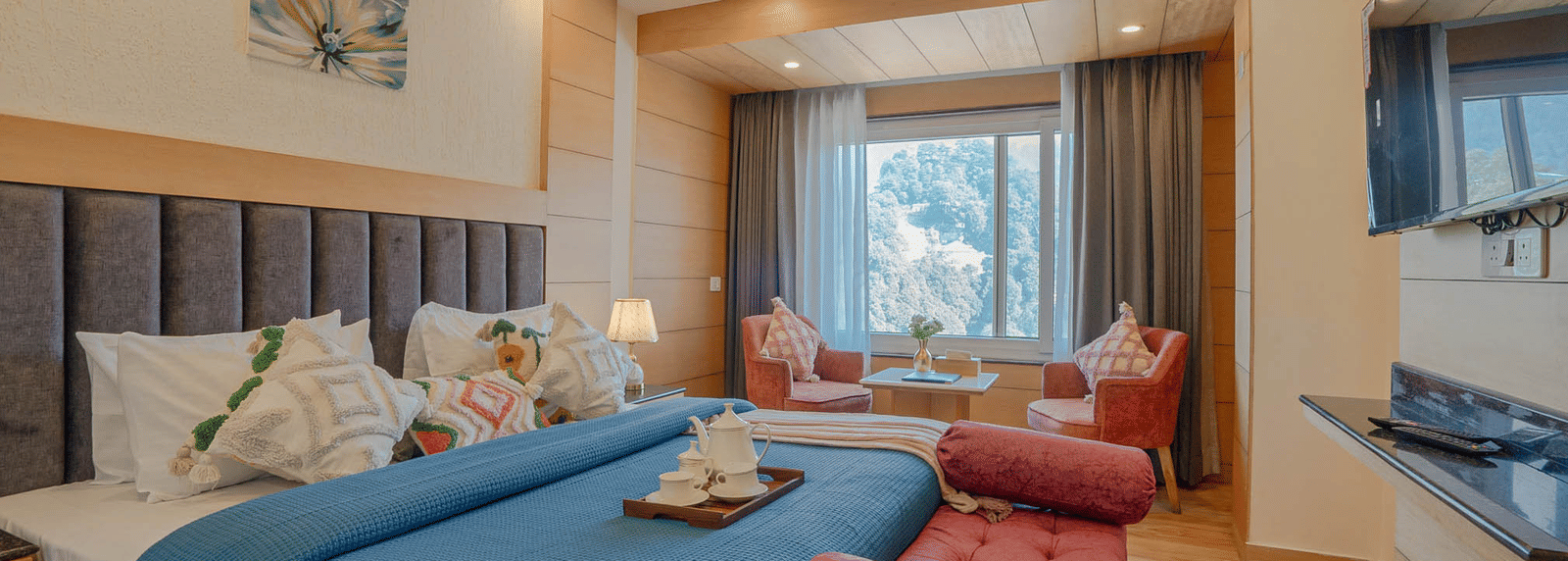 A bedroom with a king size bed, seating area, and window view at Perfectstayz Premium at Mall Road Hotel Super, Mussoorie.