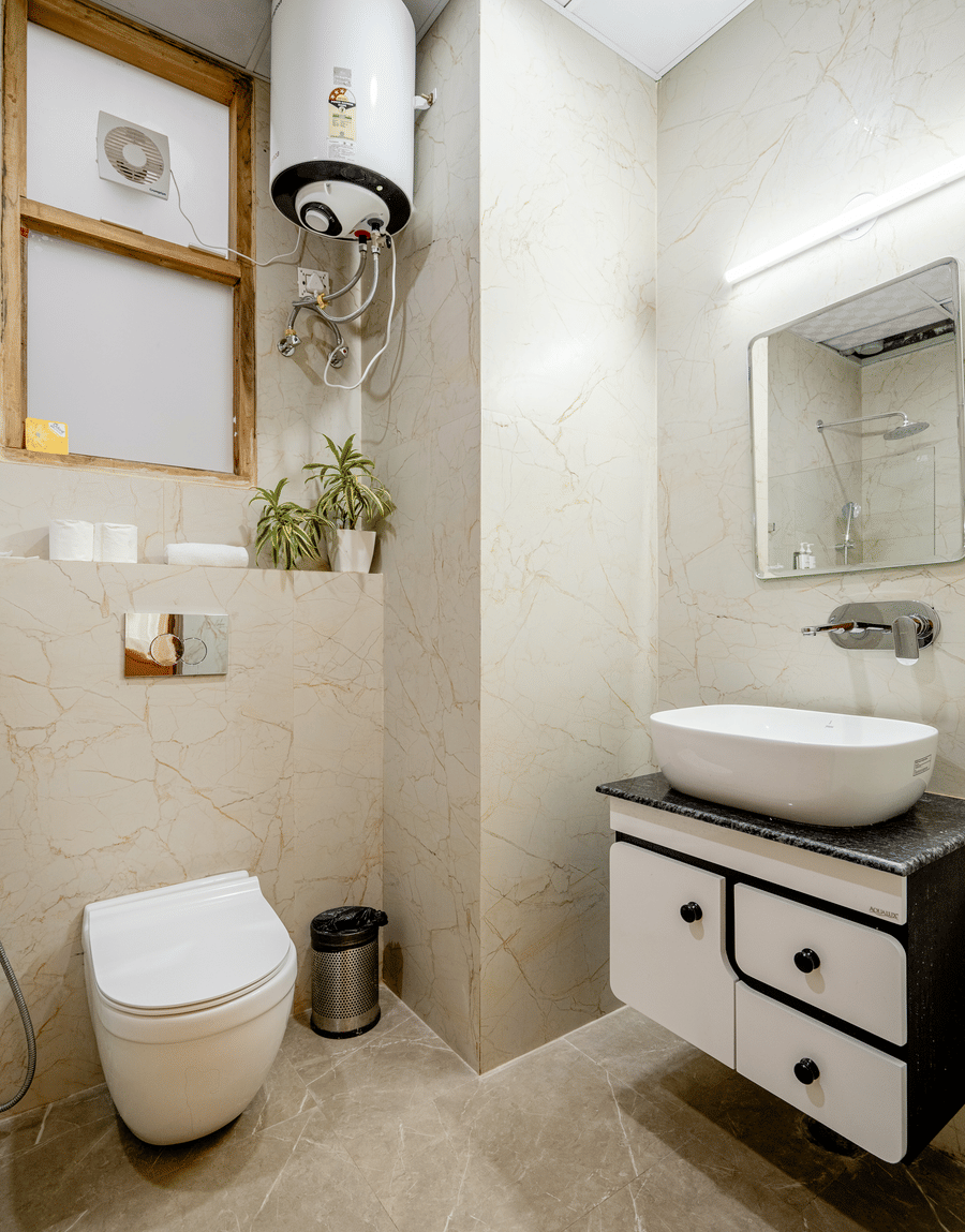 Contemporary hotel en-suite bathroom with a white ceramic washbasin vanity unit and a wall-mounted toilet.