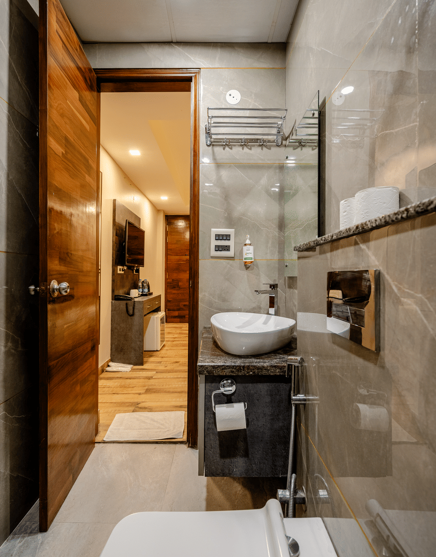 Bathroom with a vessel washbasin, a towel rack and a glass shower in the Deluxe Twin Room at Lime Tree Hotel Near Medanta