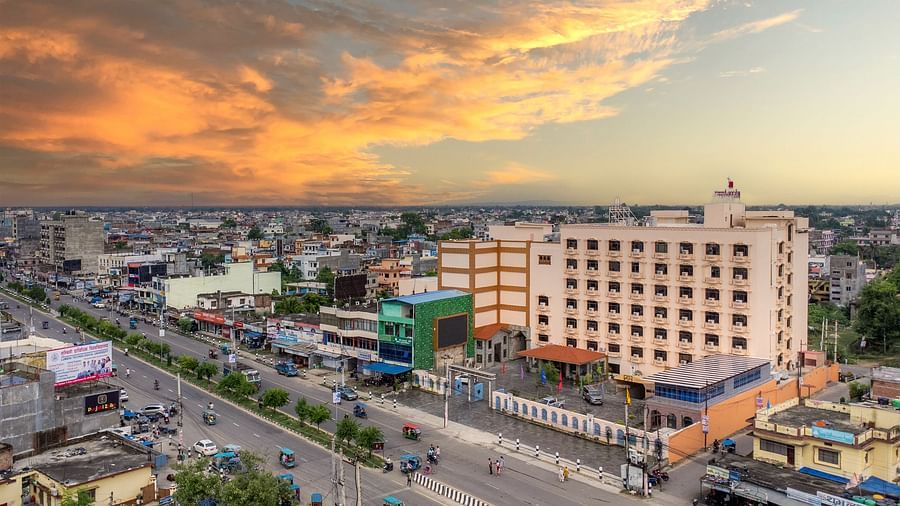 Aerial view of Diamond Palace Lords Plaza in Nepalgunj amidst a cityscape under a dramatic, colorful sky.