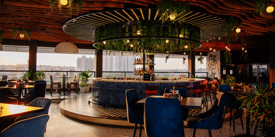Sophisticated restaurant setting with panoramic city views and natural light. | The Icon Select by Bhagini, Mahadevapura