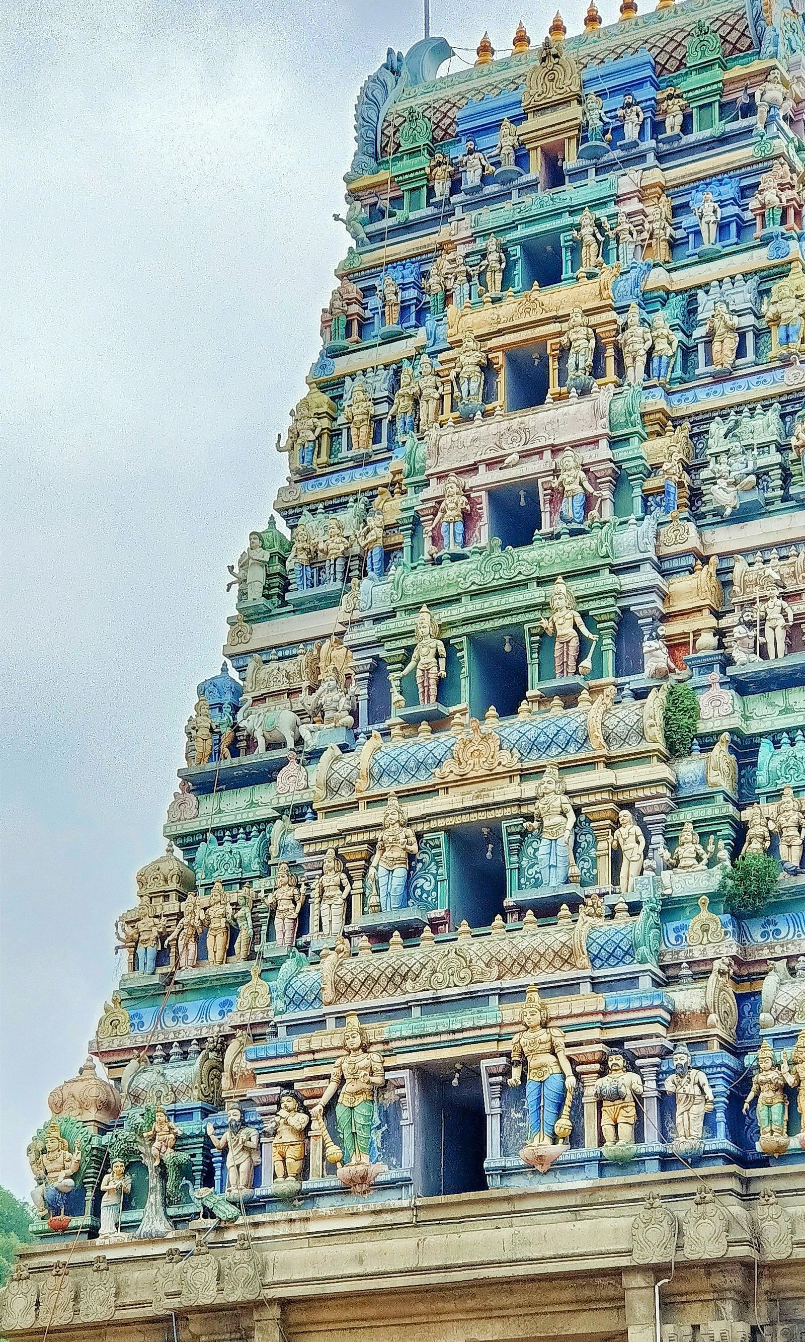  The temple spire rises clearly against a sky dotted with scattered clouds.