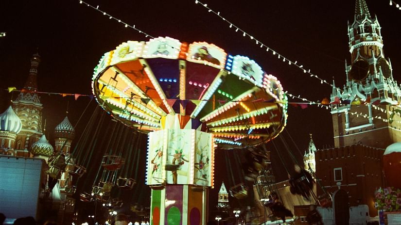 An image of a fair with rides decorated with lights during night time