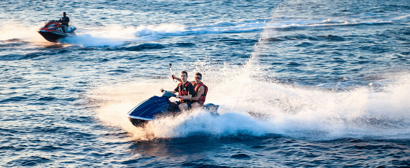 Image of people riding a jet boat on a waterbody.