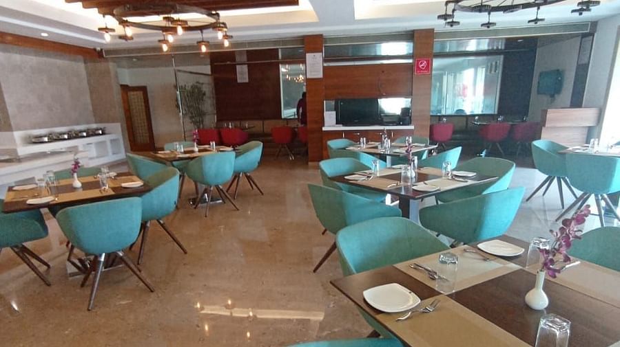 Restaurant dining area at Rang Lords Inn with teal chairs and set tables