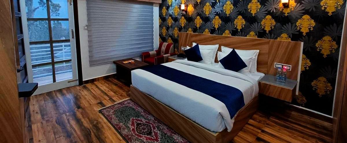 A Deluxe Room at DLS Nature Trinket Resort with a king size bed and a large window.