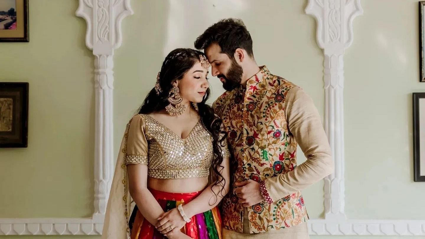 A couple stands together, dressed in colourful traditional attire - Umaid Palace - Best Luxury Heritage Resort Near Jaipur. 