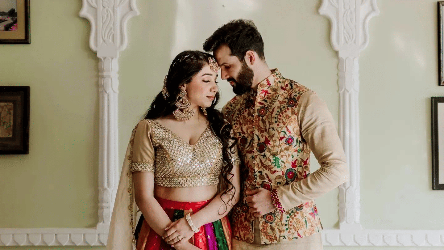 Bride and groom posing indoors in traditional attire during a wedding photoshoot.