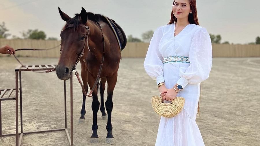 a woman standing by a horse at Themis Mudhouse - A Nature's Retreat Resort & Wellness