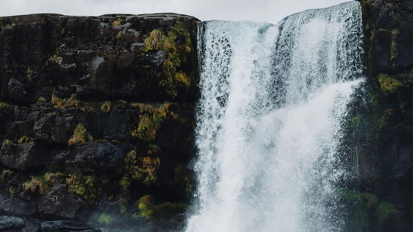 Image of a waterfall cascading through rocks with a glommy sky in the background - The Dukes Retreat, Khandala