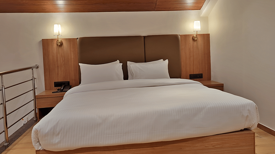 Bedroom featuring a double bed, wooden headboard, bedside lights, and ceiling lighting