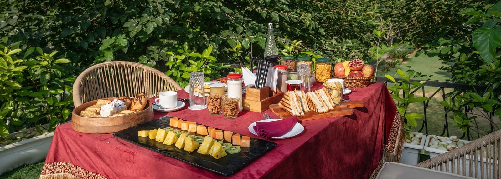 A table filled with food set in an outdoor space surrounded by lush plants at Valley by Grassfield.