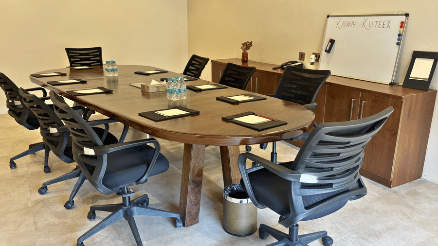 Overview of a meeting room at Kadamb Kuteer, Vrindavan with a large oval conference table and several office chairs.