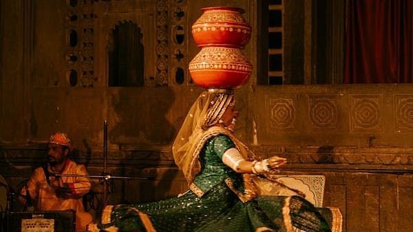A person dancing with two pots on her head.