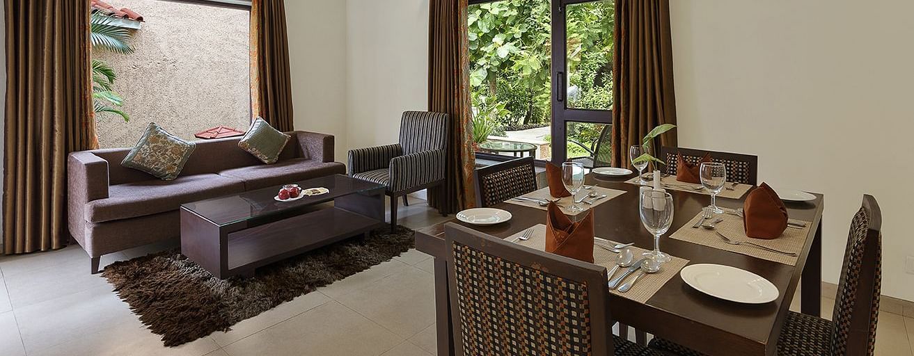 An image of a living area with sofa set and dining area on the other side. There is also a flat TV screen on the wall - The Riverview Retreat, Corbett