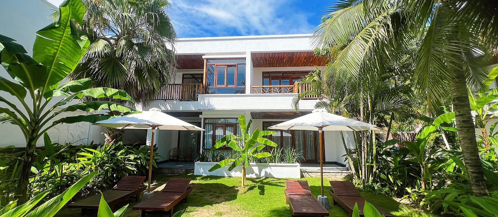 A serene view of one of our accommodations covered in lush greenery seen on a sunny day - Alibu Resorts Nha Trang