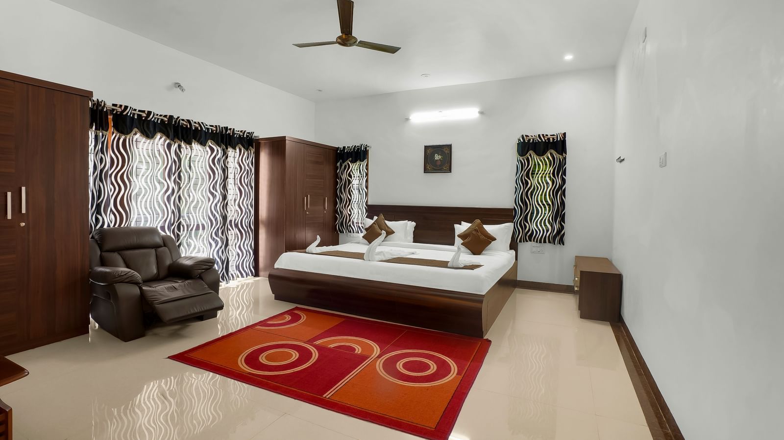 A spacious bedroom with a large bed and wooden furnishings at WOW Bungalow, Yercaud.