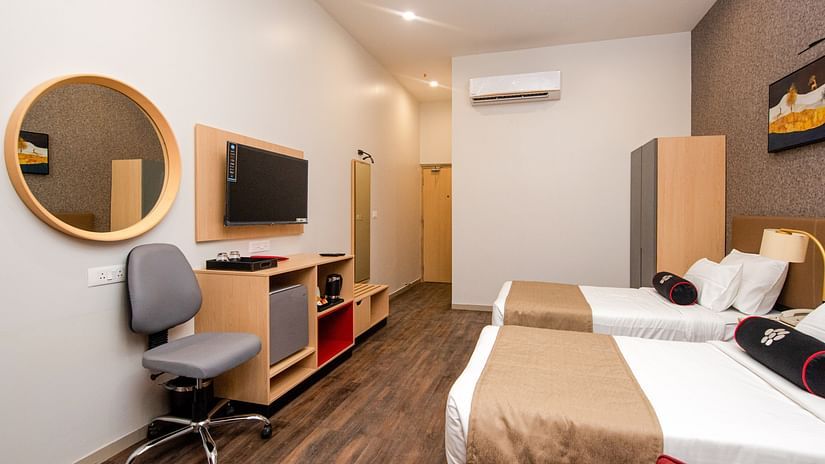 side angle view of premier room with white walls and a work desk amidst other in-room amenities - Mastiff Hotel, Ankleshwar