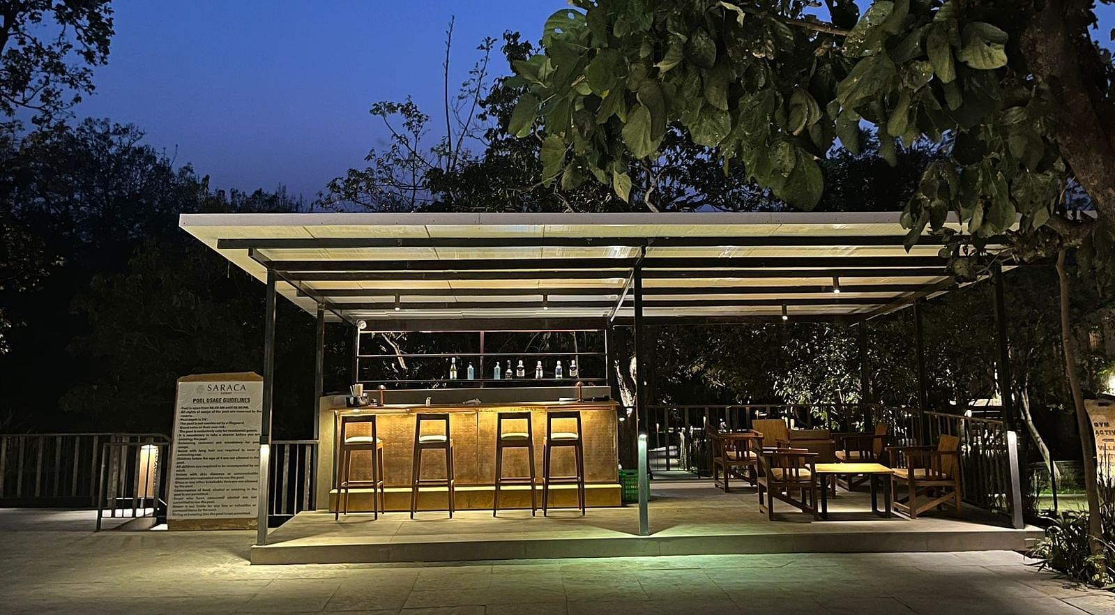 Outdoor seating arrangement at the Pool Bar at Saraca Resort & Spa Corbett during blue hour