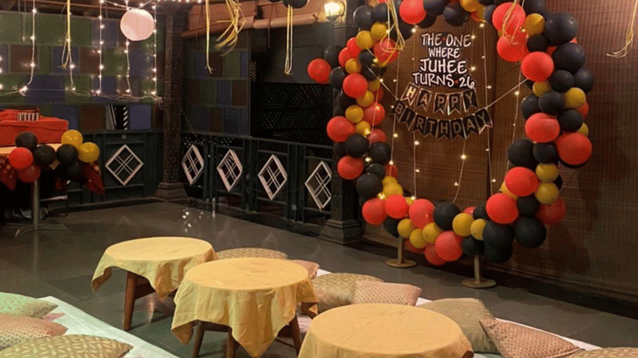 An event setup featuring low tables, floor cushions, and balloon decorations under hanging lights at Amantra Shilpi Resort, Udaipur.