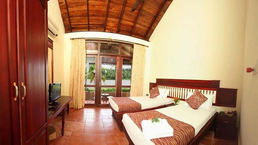  Spacious bed with decorative blankets, flanked by two bedside tables with lamps, and a large window to the side