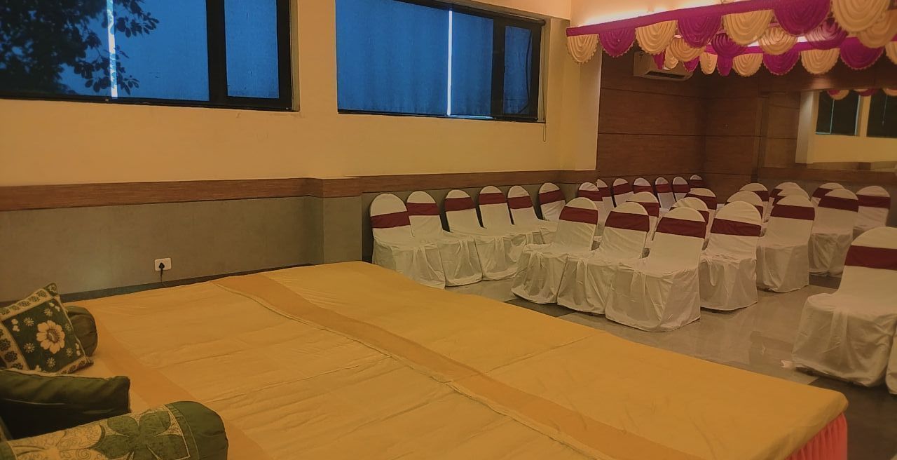 Event hall with low seating stage and chairs arranged in rows at Max Hotel Prayagraj.