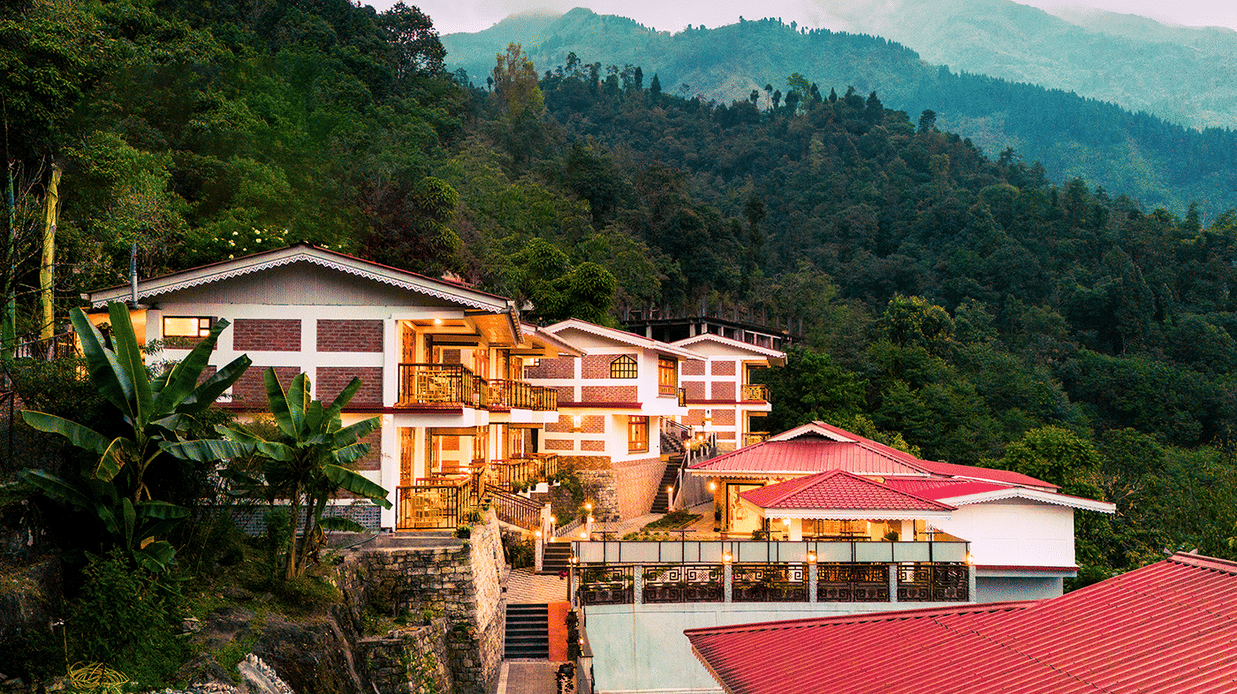 Voyage Songfum Retreat in Gangtok — a serene hillside hotel surrounded by lush greenery and offering scenic mountain views.