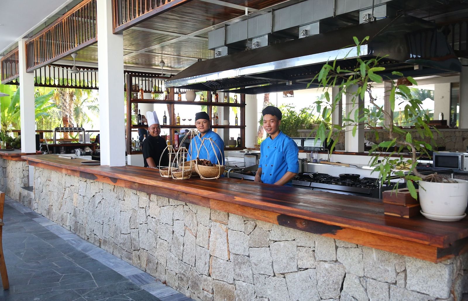 A counter in our restaurant with two attenders standing in blue uniforms behind the counter - Alibu Resort Nha Trang