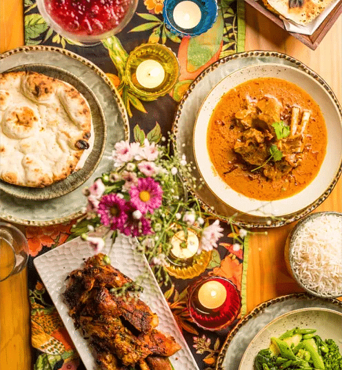 Overhead shot of a vibrant Indian meal spread featuring a variety of colourful traditional dishes at Karma Chalets.