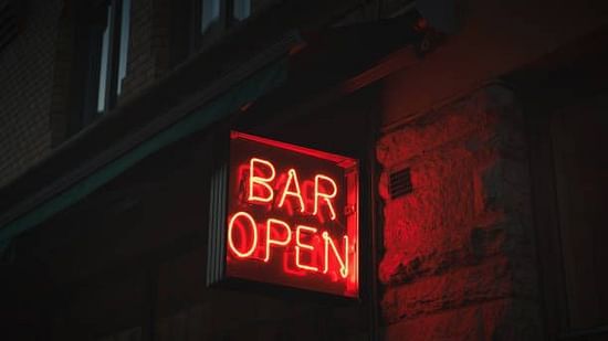 Bar open sign illuminated, indicating the availability of drinks and late-night service.