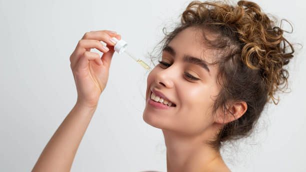 a girl applying serum on her face - Skin Treatment Mumbai