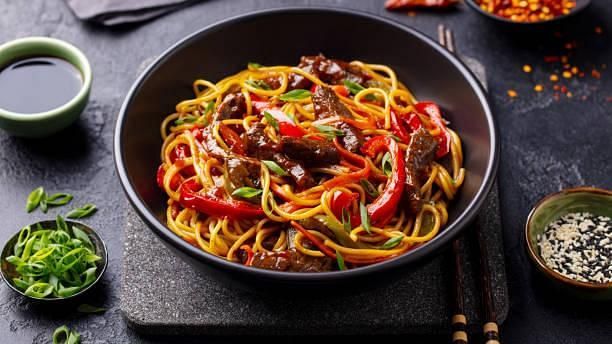 A bowl of vibrant spaghetti with herbs and spices
