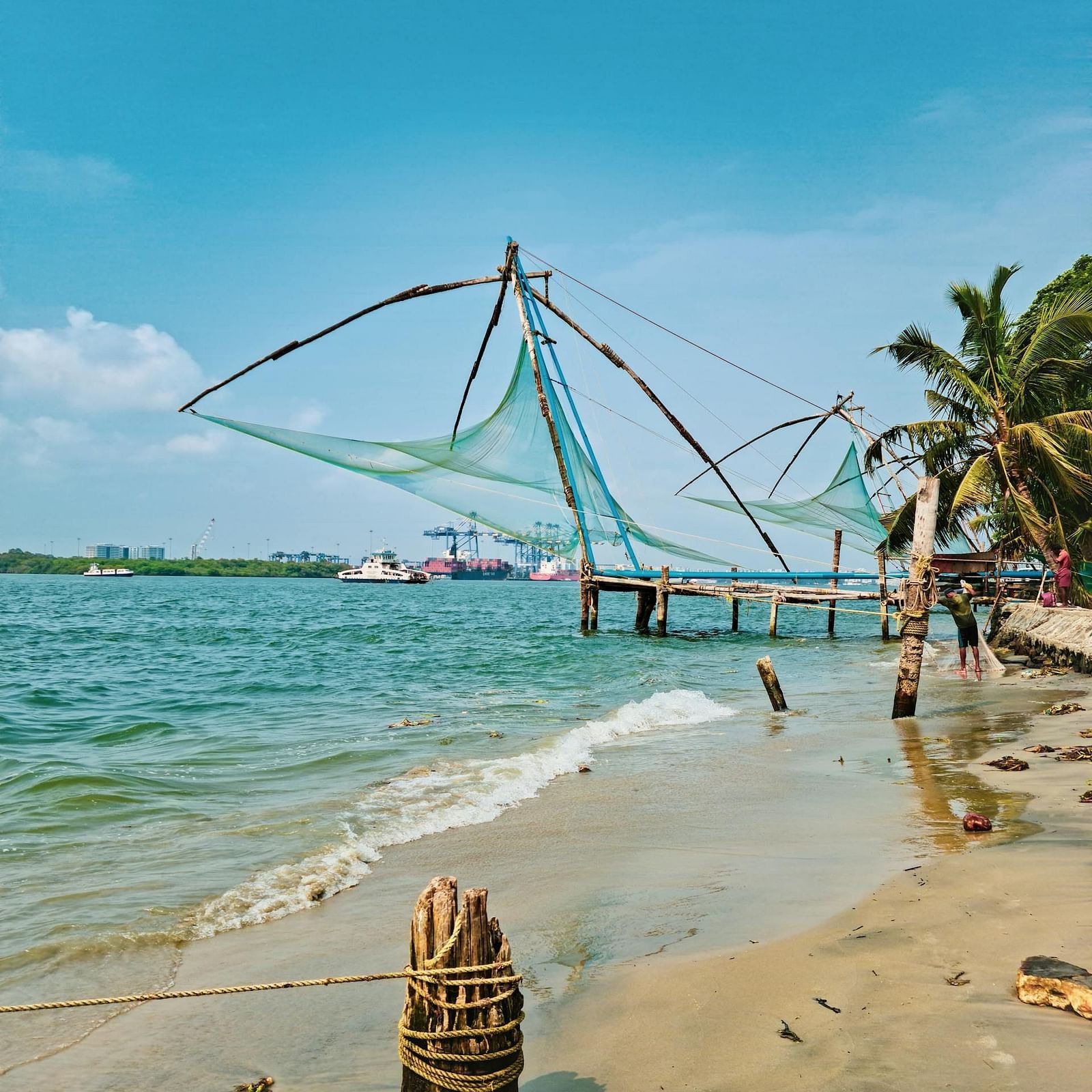 an image of a sea at Kochi with Chinese fish net with a dock surrounded by coconut trees.