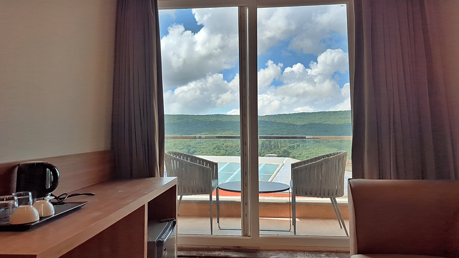 balcony with seating area with green landscape in the view.